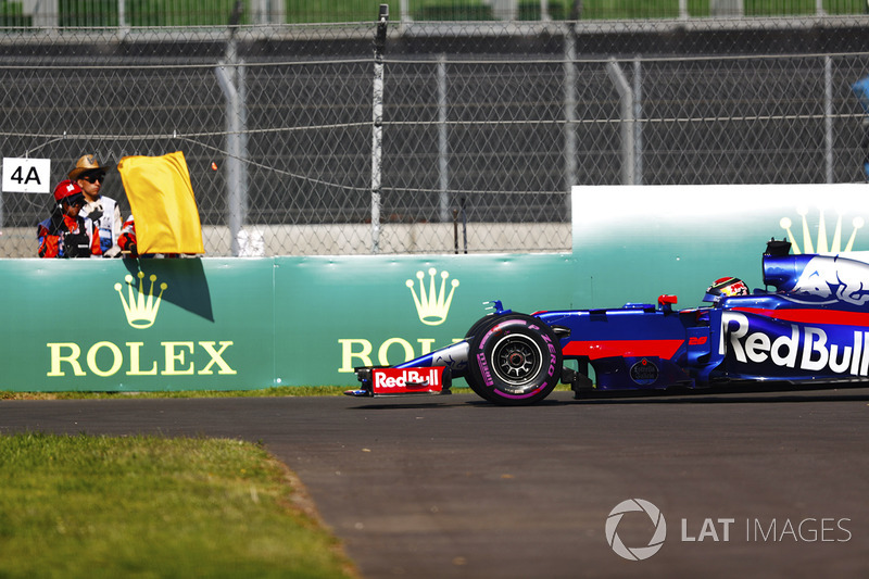 Brendon Hartley, Scuderia Toro Rosso STR12, detenido en pista en los PL1, un mariscal muestra una bandera amarilla