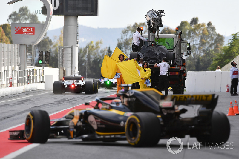 Marshals wave yellow flags in pit lane