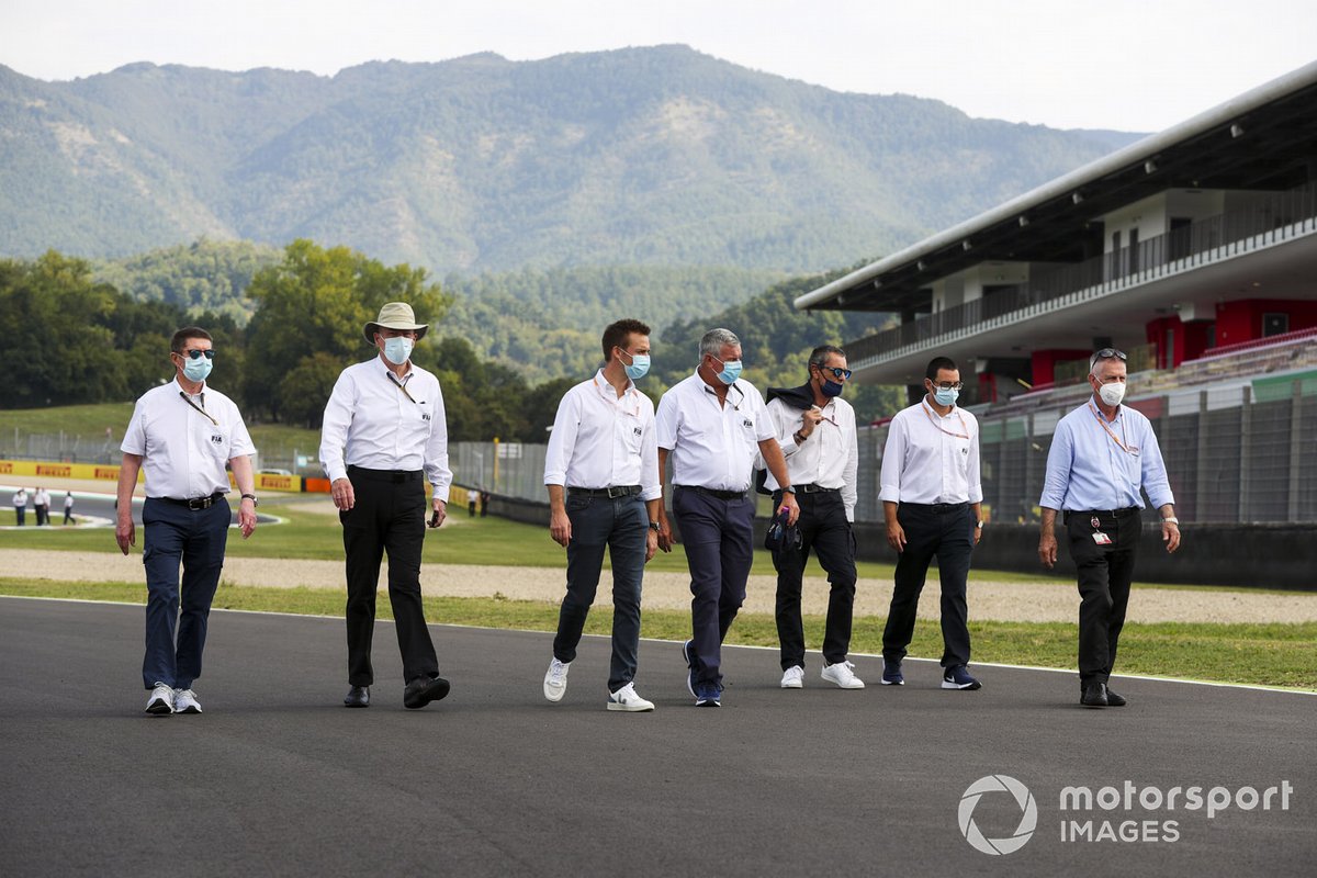 FIA members walk the track