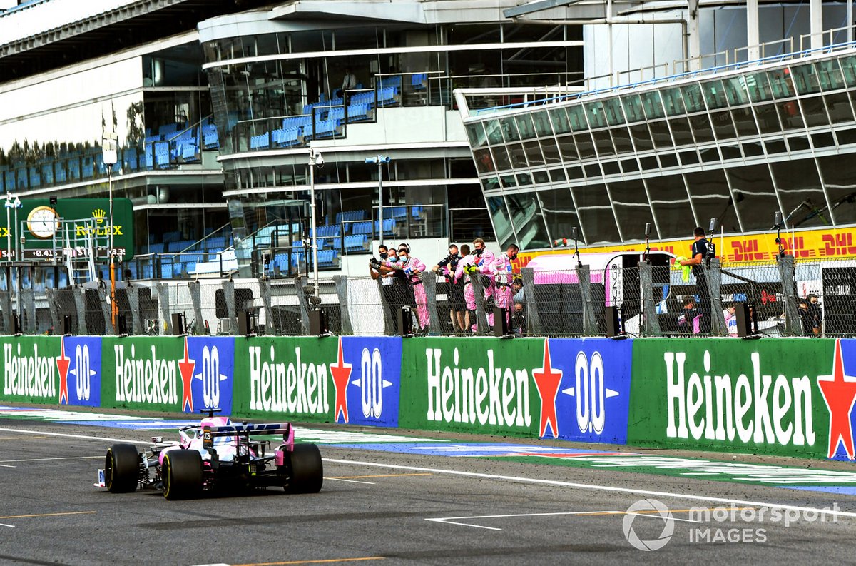 Sergio Perez, Racing Point RP20, passes his team on the pit wall at the end of the race