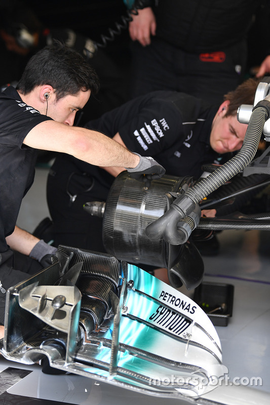 Mecánicos de Mercedes realizando ajustes en los frenos del W08
