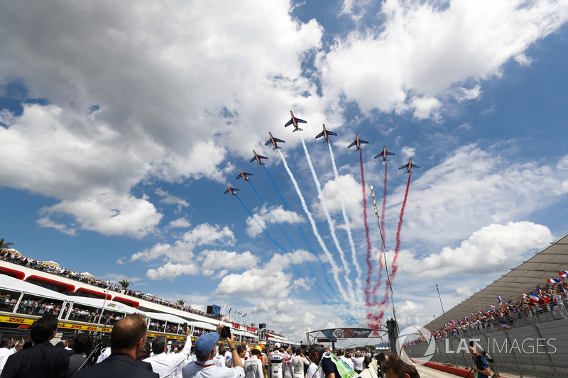 The French Air Force Aerobatics team, La Patrouille de France, overfly the grid in their Dassault Alpha Jet Es