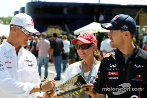 Michael Schumacher, Mercedes AMG F1 and Sebastian Vettel, Red Bull Racing with a fan