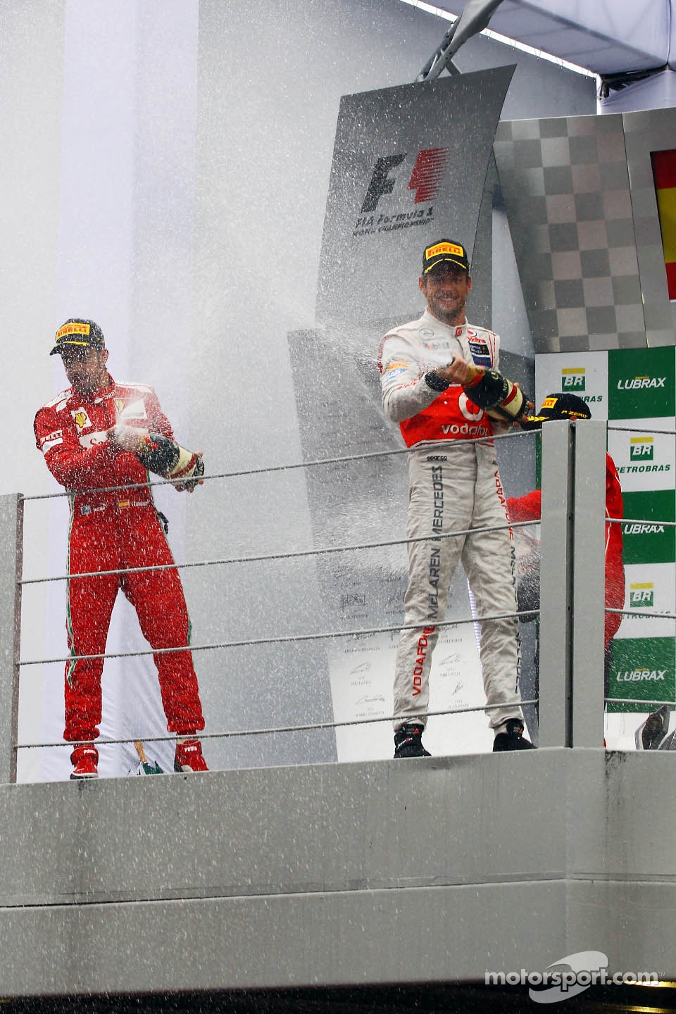 Race winner Jenson Button, McLaren celebrates on the podium with Fernando Alonso, Ferrari