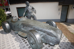 Una estatua de bronce de Juan Manuel Fangio y su Mercedes-Benz W196 en la entrada de la pista