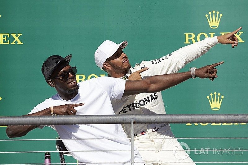 Usain Bolt doet zijn pose met Lewis Hamilton, Mercedes AMG F1, op het podium