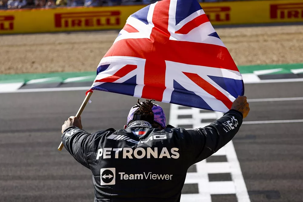 Lewis Hamilton, Mercedes, 1st position, celebrates with a Union flag after the race