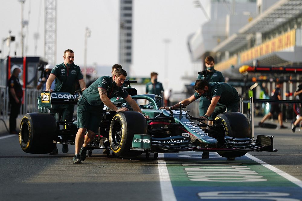 Monteurs duwen de auto van Lance Stroll, Aston Martin AMR21, in de pitlane