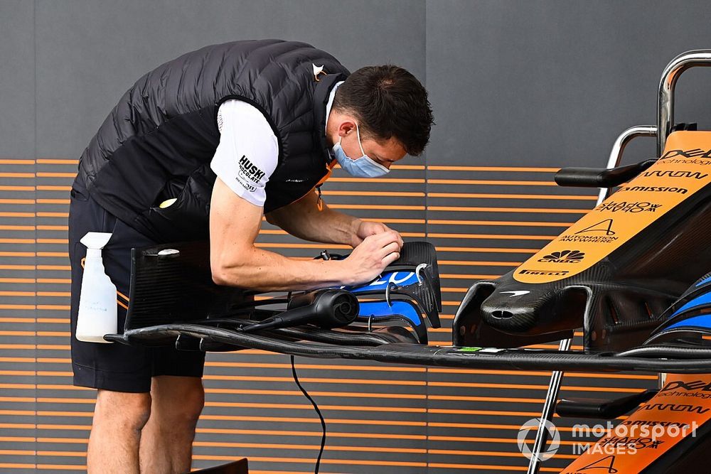 A McLaren mechanic at work on a front wing endplate