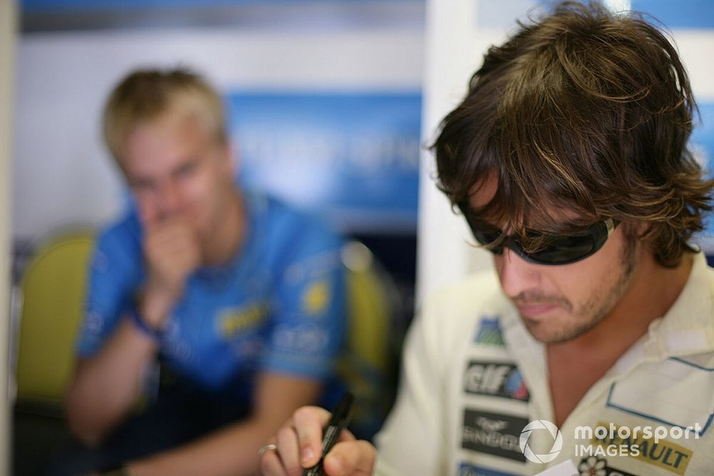 Fernando Alonso, Renault, with team mate and test driver, Heikki Kovalainen in the background