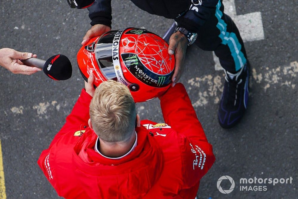 Mick Schumacher, Alfa Romeo Racing, entrega al ganador de la carrera Lewis Hamilton, Mercedes-AMG F1, el casco Mercedes de su padre, Michael Schumacher de 2012