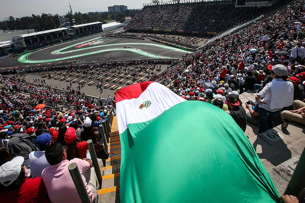 Sergio P&eacute;rez, Sahara Force India VJM10 y la bandera de M&eacute;xico en la tribuna