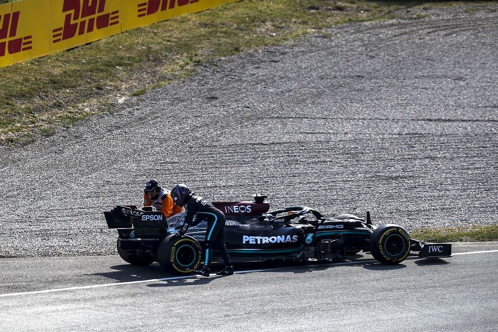 A marshal assists Lewis Hamilton, Mercedes W12, after a break down during FP2