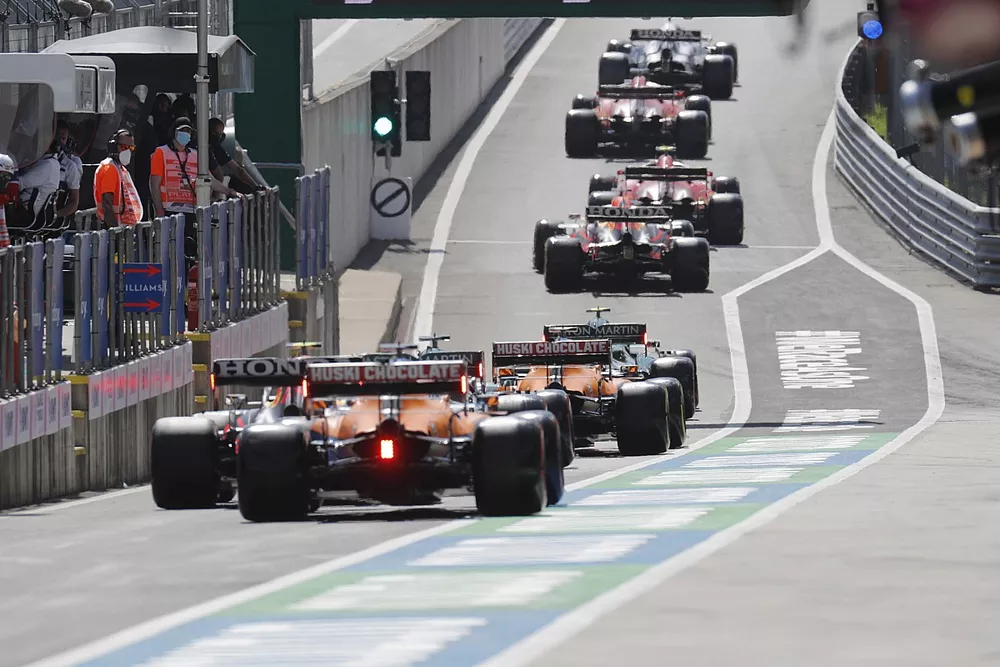 Sergio Perez, Red Bull Racing RB16B , and Daniel Ricciardo, McLaren MCL35M, in the queue to leave the pit lane