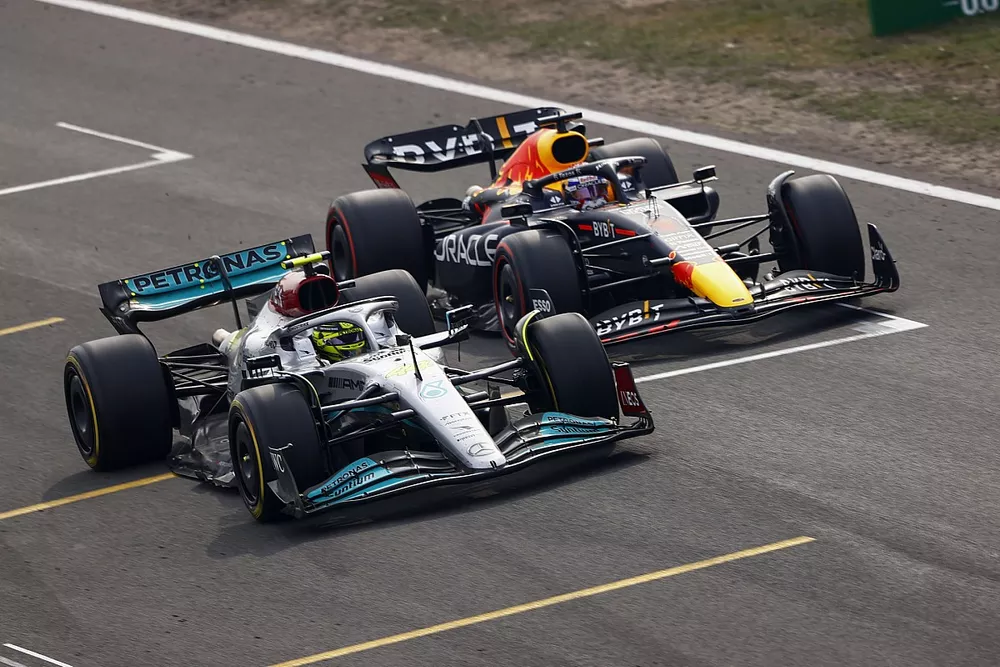 Lewis Hamilton, Mercedes W13, battles with Max Verstappen, Red Bull Racing RB18, for the lead after the restart