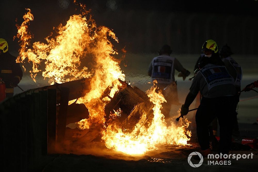 Marshals extinguish the flames after a big crash for Romain Grosjean, Haas VF-20, on the opening lap