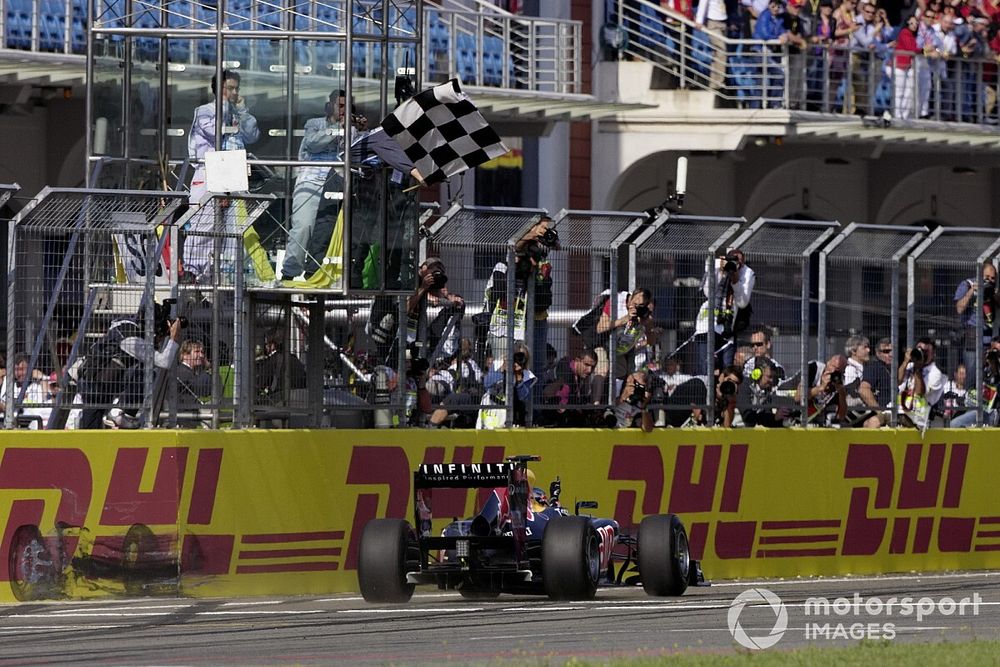 Sebastian Vettel, Red Bull RB7 Renault, crosses the finish line and takes the chequered flag