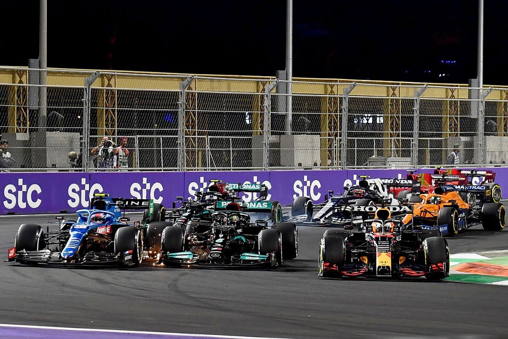 Max Verstappen, Red Bull Racing RB16B, Esteban Ocon, Alpine A521, and Lewis Hamilton, Mercedes W12, battle for position at the restart