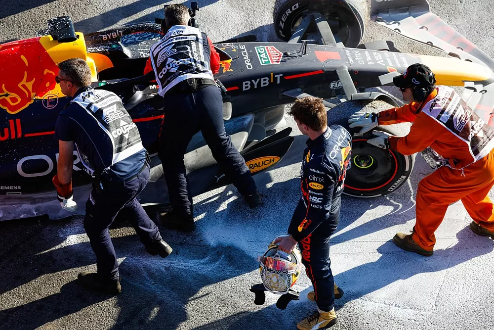 Marshals assist Max Verstappen, Red Bull Racing, after retiring from the race