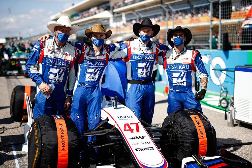 Haas F1 team members on the grid with the car of Mick Schumacher, Haas VF-21