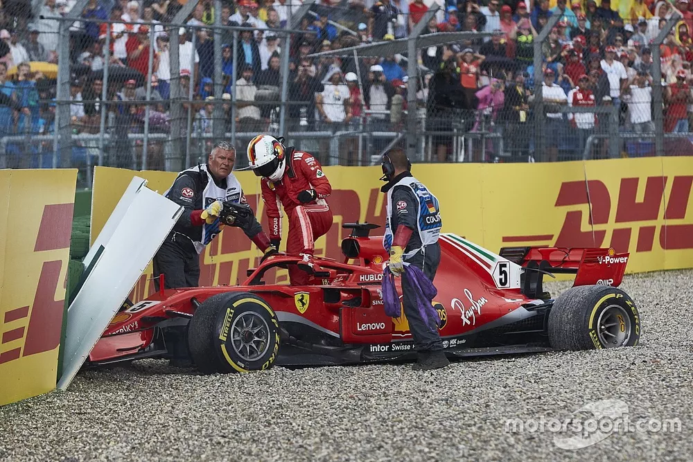 Sebastian Vettel, Ferrari SF71H, climbs out of his car after crashing out from the lead