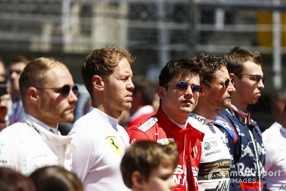 Valtteri Bottas, Mercedes AMG F1, Sebastian Vettel, Ferrari, Charles Leclerc, Ferrari, Romain Grosjean, Haas F1, and Daniil Kvyat, Toro Rosso, line up with the grid kids for the national anthem prior to the start