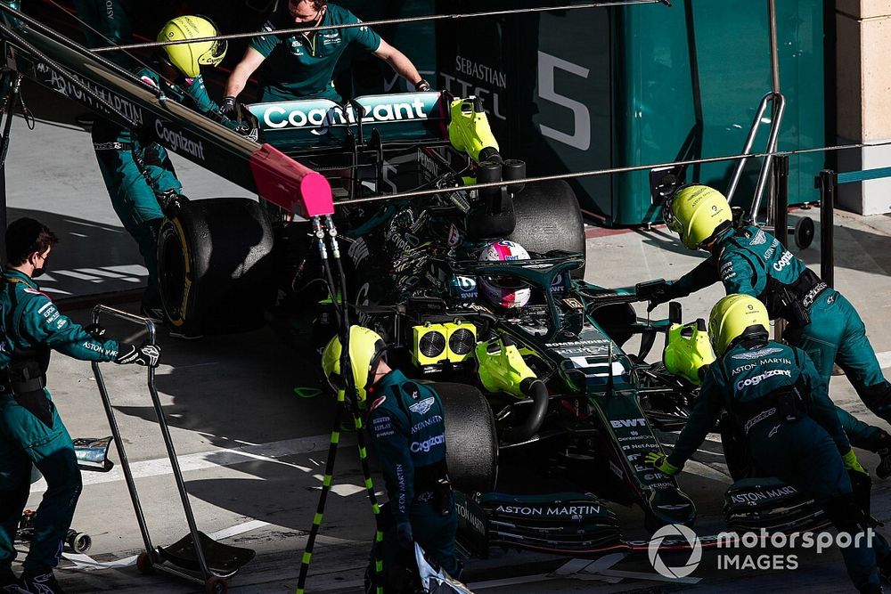 Monteurs duwen Sebastian Vettel, Aston Martin AMR21, terug in de pitbox