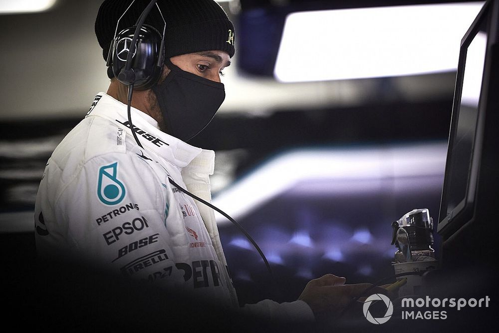 Lewis Hamilton wears a protective face mask in the garage 