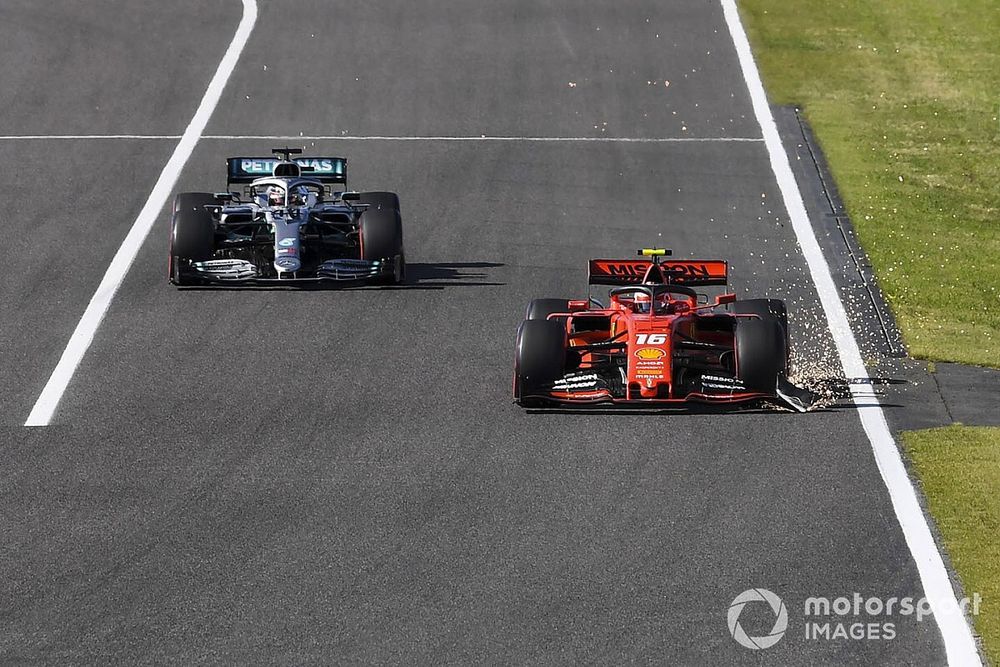 Charles Leclerc, Ferrari SF90, leadsLewis Hamilton, Mercedes AMG F1 W10, as he trails sparks from his damaged front wing