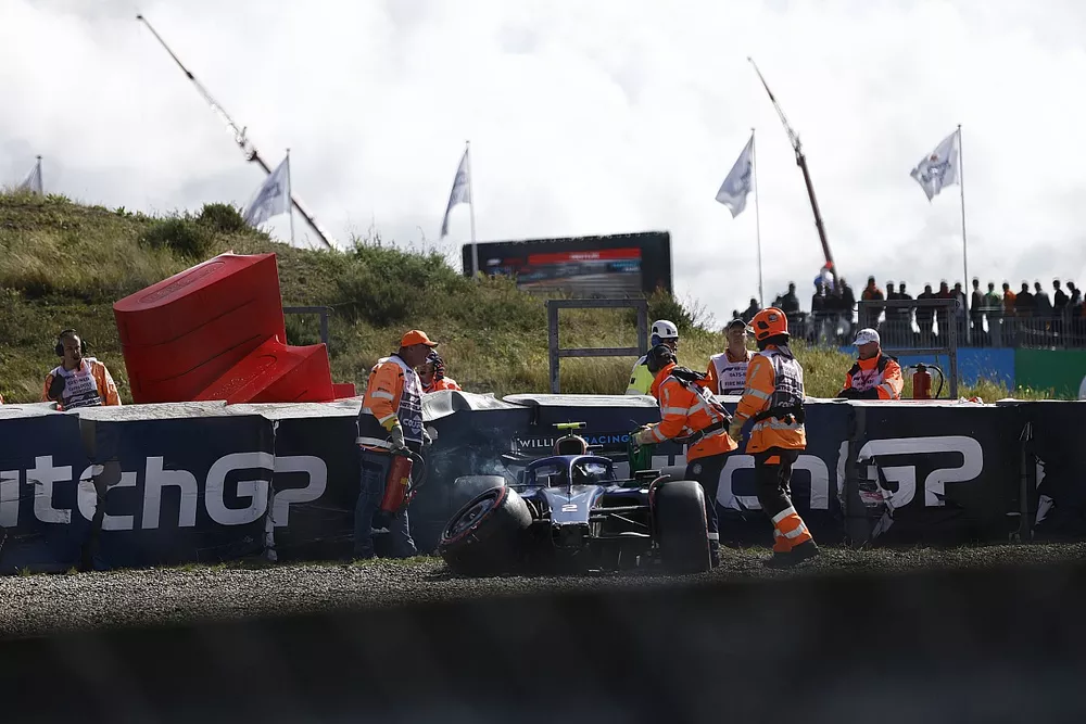 Marshals remove the car of Logan Sargeant, Williams FW45, after a crash in Q3