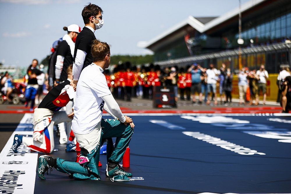 Sebastian Vettel, Aston Martin, and the other drivers stand and take a knee on the grid in support of the End Racism campaign