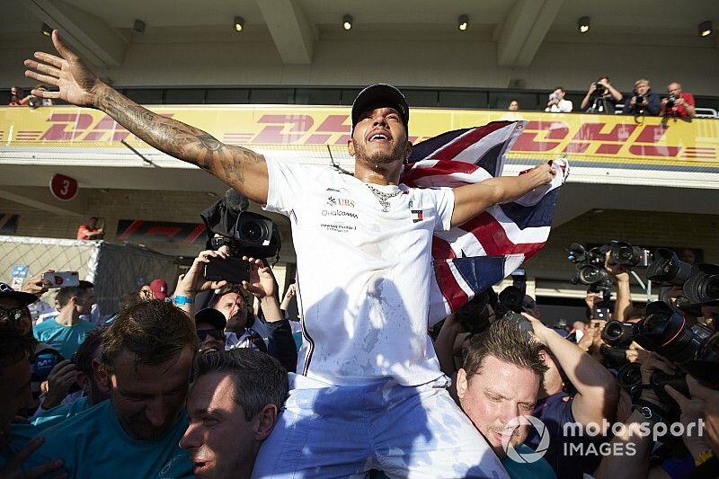 Lewis Hamilton, Mercedes AMG F1, lifts a Union Flag after winning the world championship