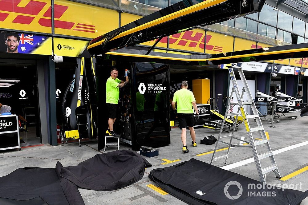 El personal de Renault guarda su equipo en los fosos...