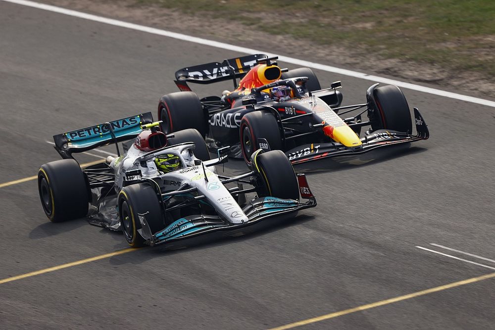 Lewis Hamilton, Mercedes W13, battles with Max Verstappen, Red Bull Racing RB18, for the lead after the restart