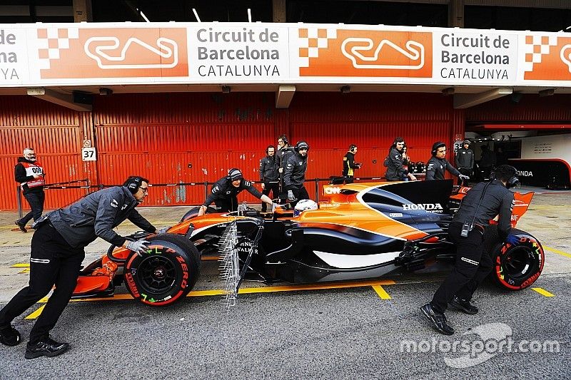 Les mécaniciens McLaren poussent la McLaren MCL32 de Fernando Alonso, McLaren, dans la voie des stands