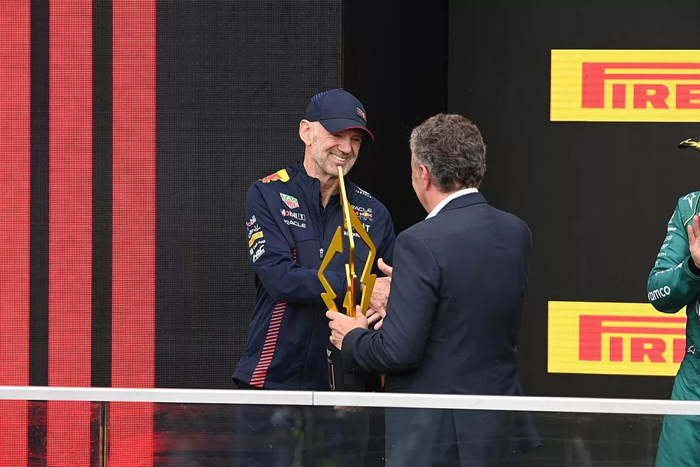 Mario Isola, director de competencia, Pirelli Motorsport, presenta a Adrian Newey, jefe técnico, Red Bull Racing, con el trofeo de constructores.
