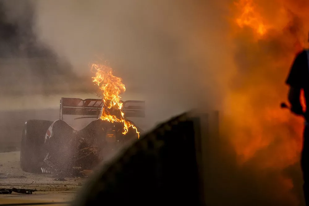 Marshals deal with the wreckage after a huge crash for Romain Grosjean, Haas VF-20, on the opening lap