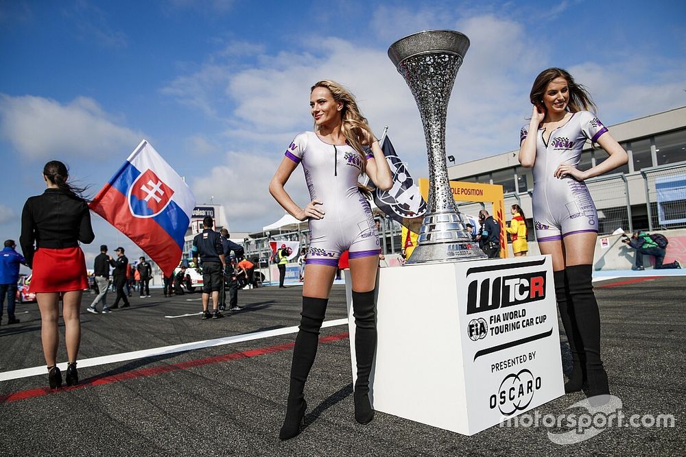 The trophy and girls on the starting grid