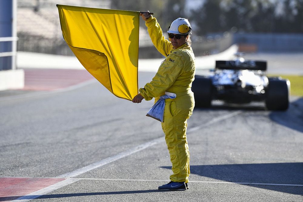 A marshal holds a yellow flag