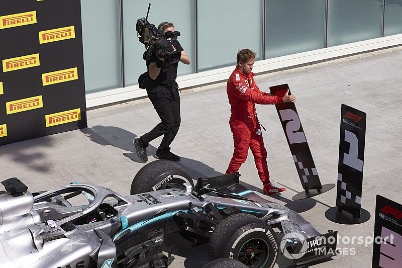 Le deuxième, Sebastian Vettel, Ferrari, change les panneaux dans le Parc Fermé