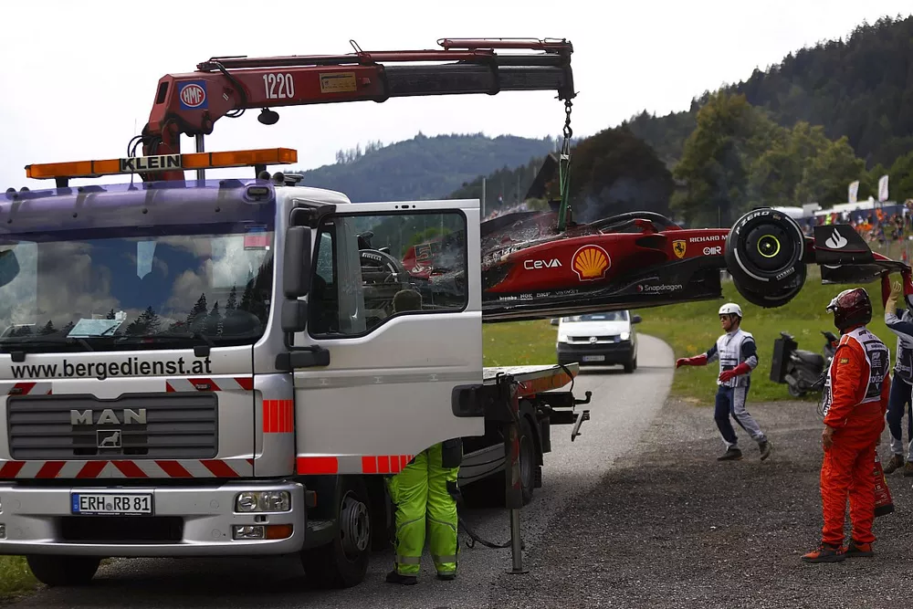 Marshals remove the fire damaged car of Carlos Sainz, Ferrari F1-75, from the circuit
