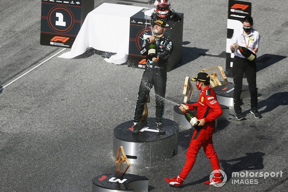 Valtteri Bottas, Mercedes-AMG Petronas F1, and Charles Leclerc, Ferrari, spray the champagne on the podium as they celebrate after the race