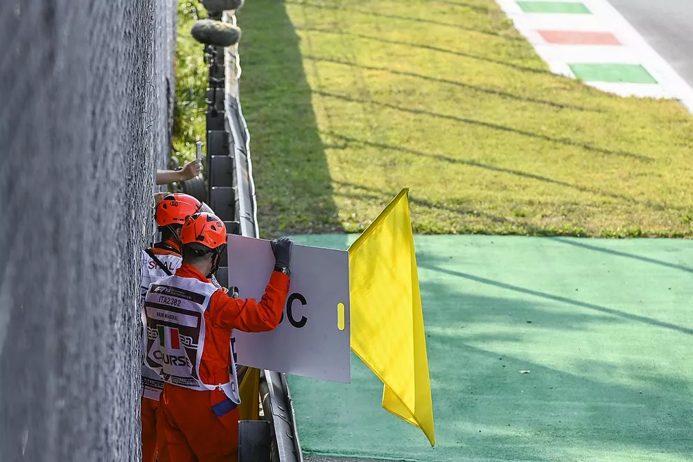 Les commissaires agitent les drapeaux jaunes et le panneau "Safety Car"