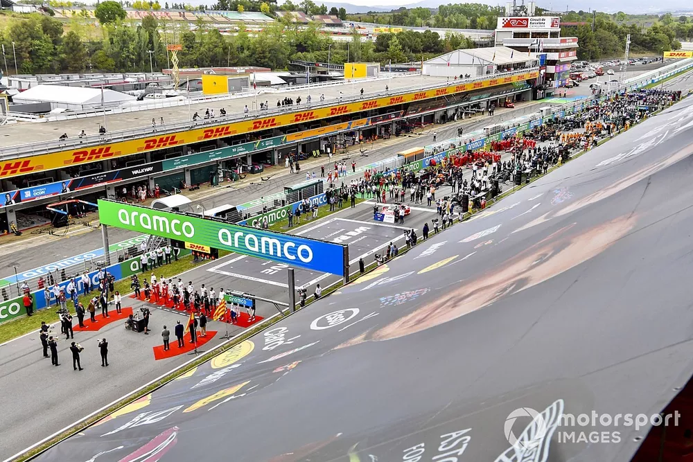 The drivers stand in line on the grid for the national anthem prior to the start