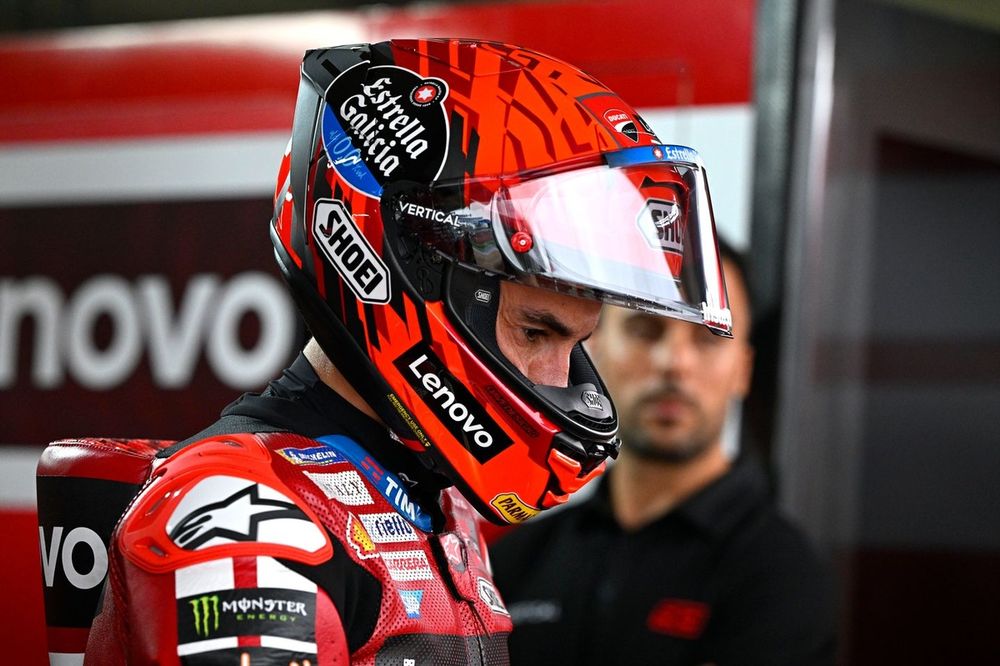Marc Márquez com o macacão da equipe Ducati ao lado de sua moto no pit lane