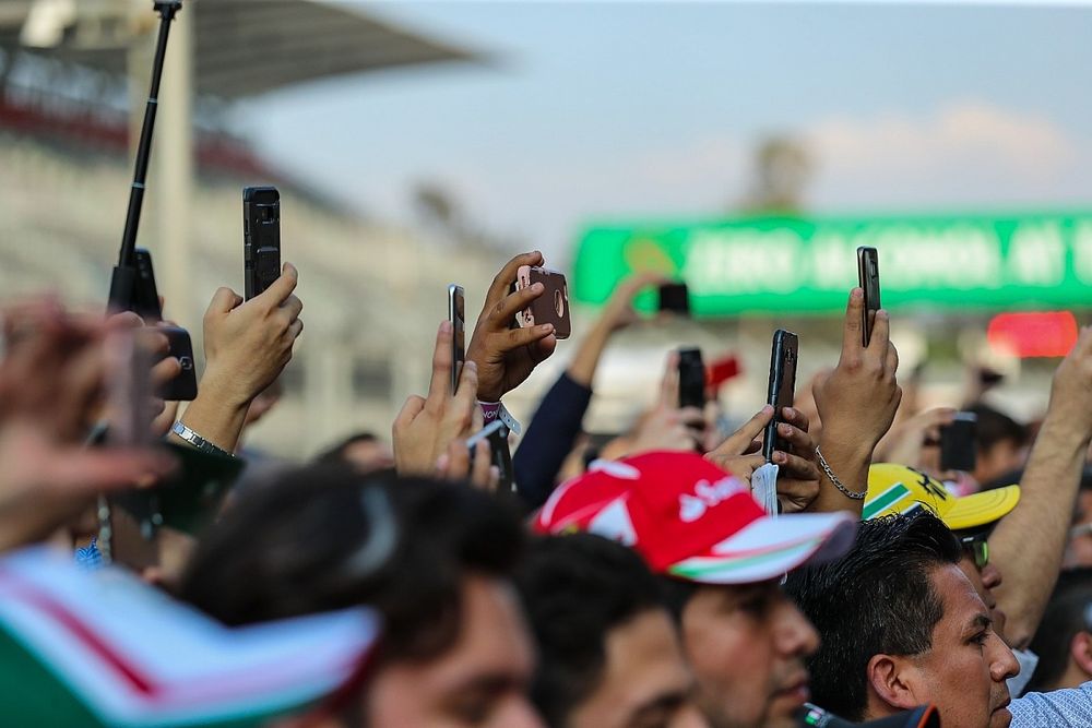 Mensen met telefoons op start-finish van het circuit