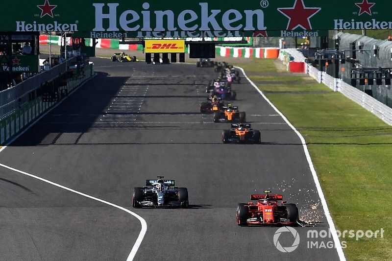 Charles Leclerc, Ferrari SF90,leads Lewis Hamilton, Mercedes AMG F1 W10, a sparks trail from his broken front wing