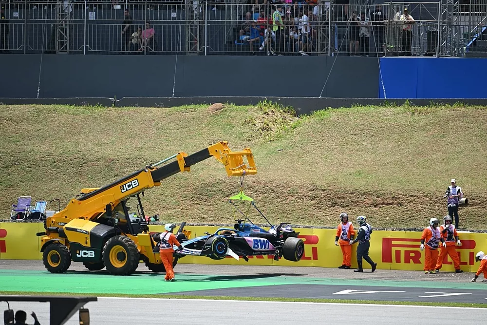 Görevliler Esteban Ocon'un hasarlı aracı Alpine A523'ü pistten çıkarıyor