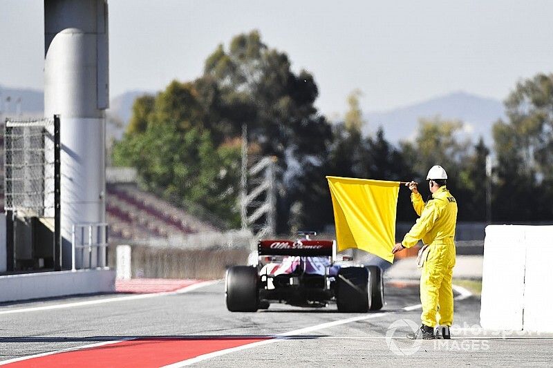 Marshal at the end o the pit lane with a yellow flag