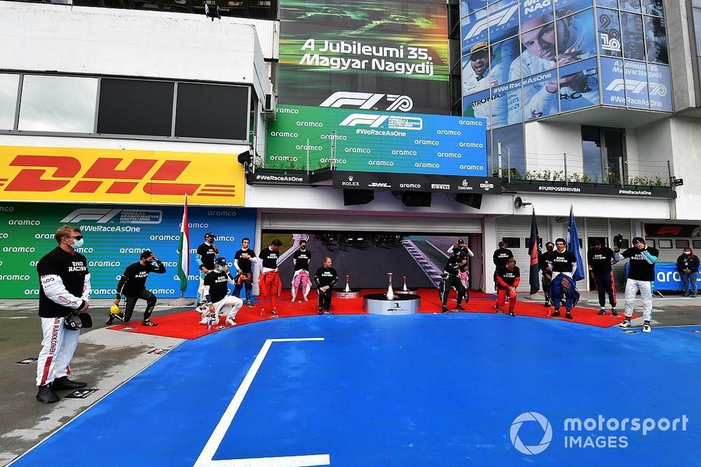 The drivers stand and kneel in support of the End Racism campaign